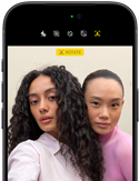 iPhone 18 Pro, noir, face avant, affichant deux modèles qui posent pour la caméra, mettant en avant la caméra avant Center Stage